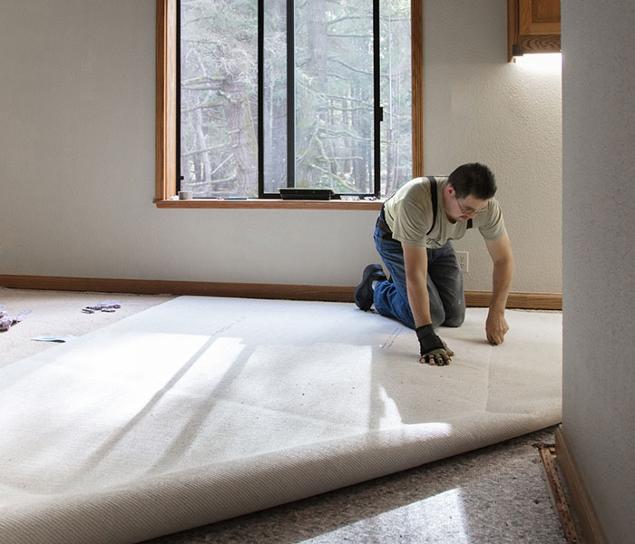 man installing carpeting in home
